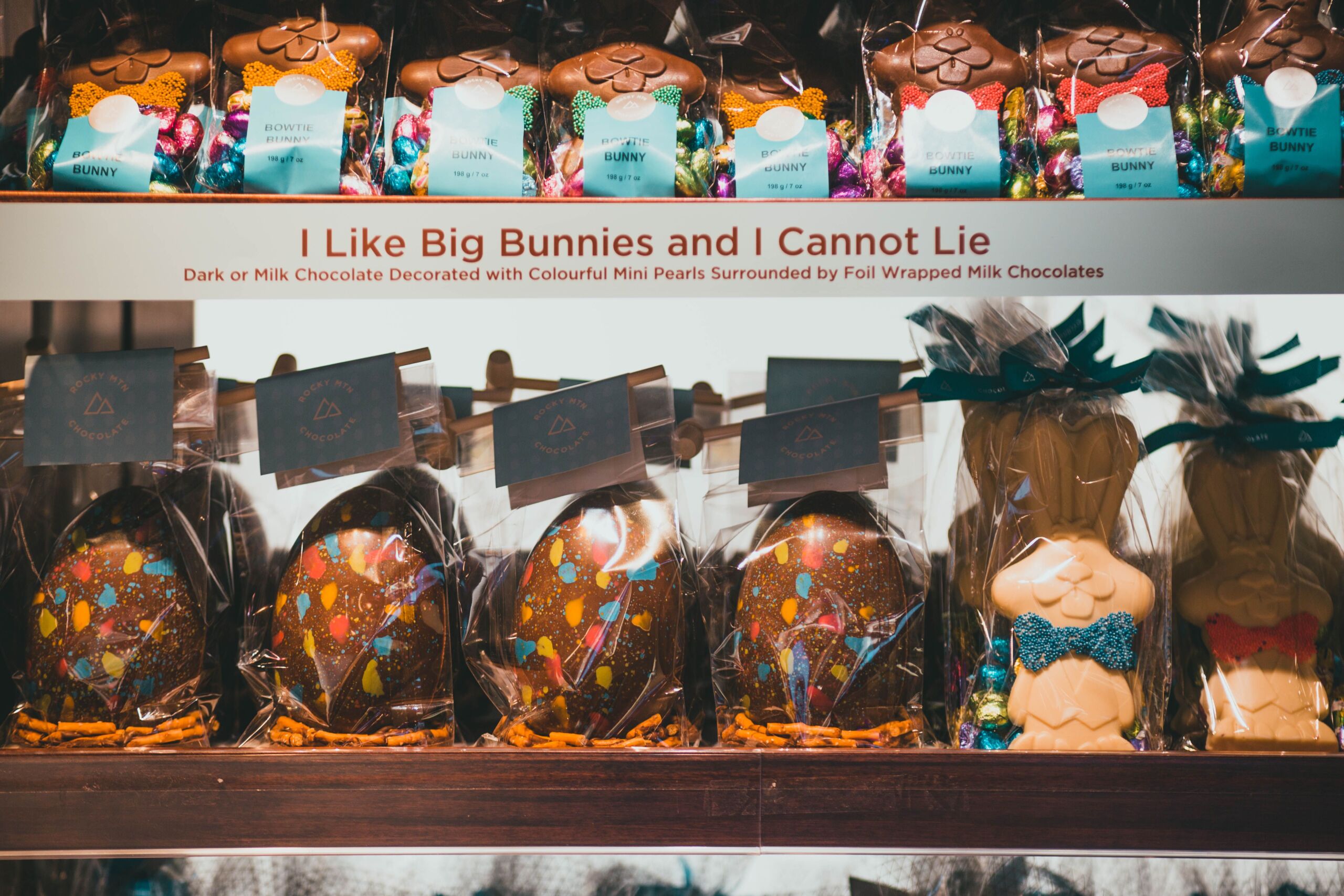Colorful Easter display with chocolate bunnies and eggs decorated with mini pearls and foil wrap.