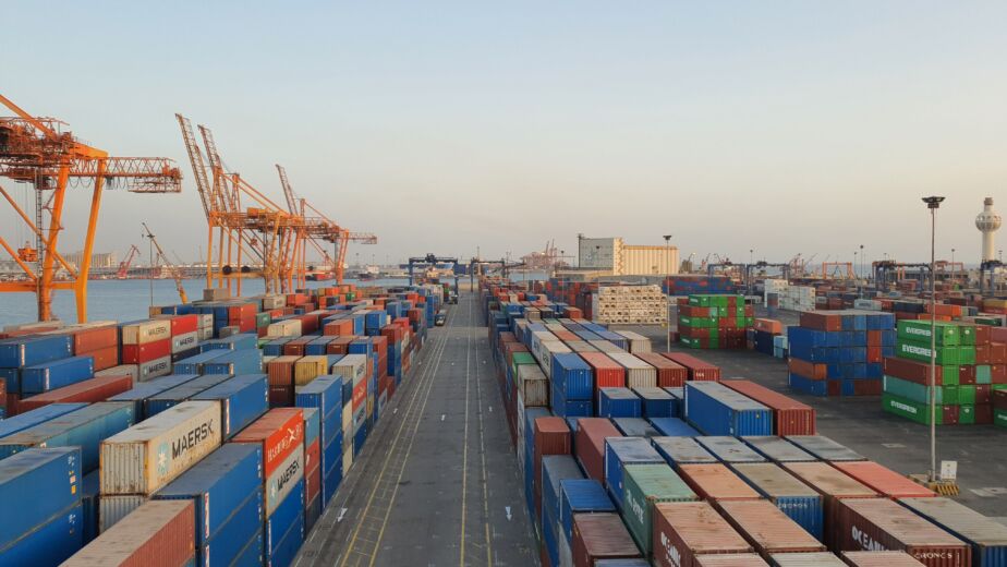 A bustling port scene with colorful cargo containers at sunrise. Ideal for logistics concepts.